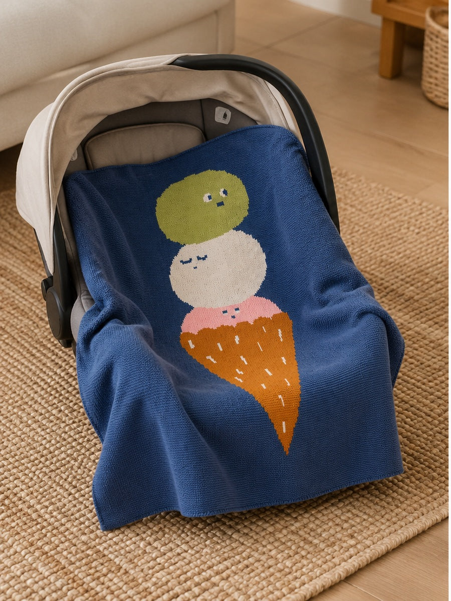Blue Ice Cream Biquette Mini knit blanket designed by Jennifer Bouron featuring a colorful 3 ice cream scoop design, draped over an infant car seat.